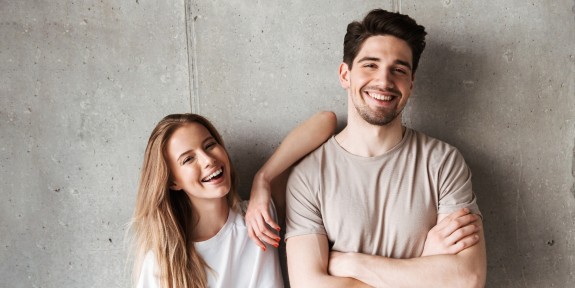 Zwei junge Menschen stehen lachend nebeneinander