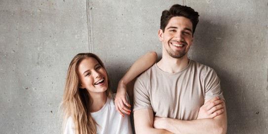 Zwei junge Menschen stehen lachend nebeneinander